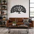Black metal peacock wall art with intricate feather cutouts, mounted above a brown leather sofa in a living room.