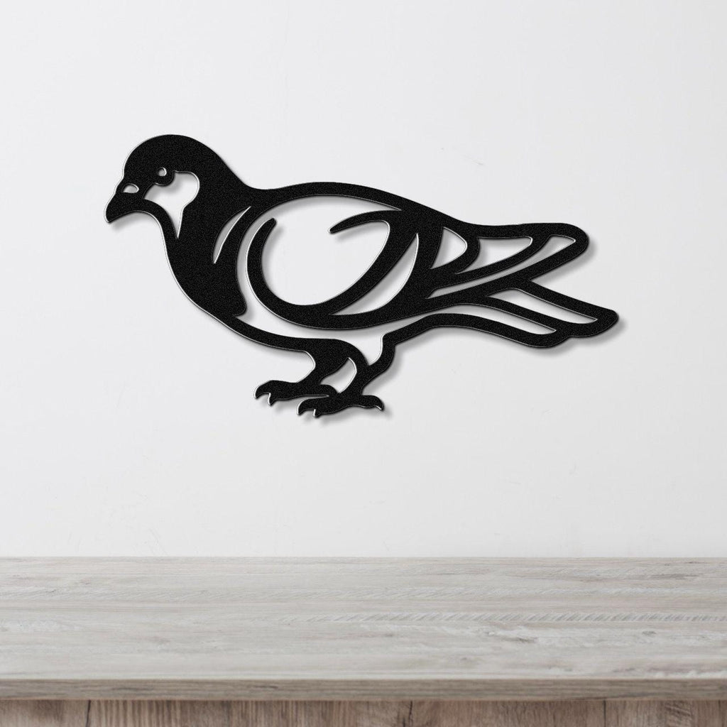 Black metal pigeon wall art with internal cutout details, mounted on a white wall above a light wood countertop.