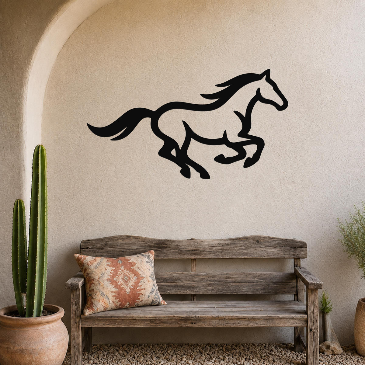 Black metal horse wall art in a running silhouette, mounted on a stucco wall above a wooden bench in a rustic patio setting.