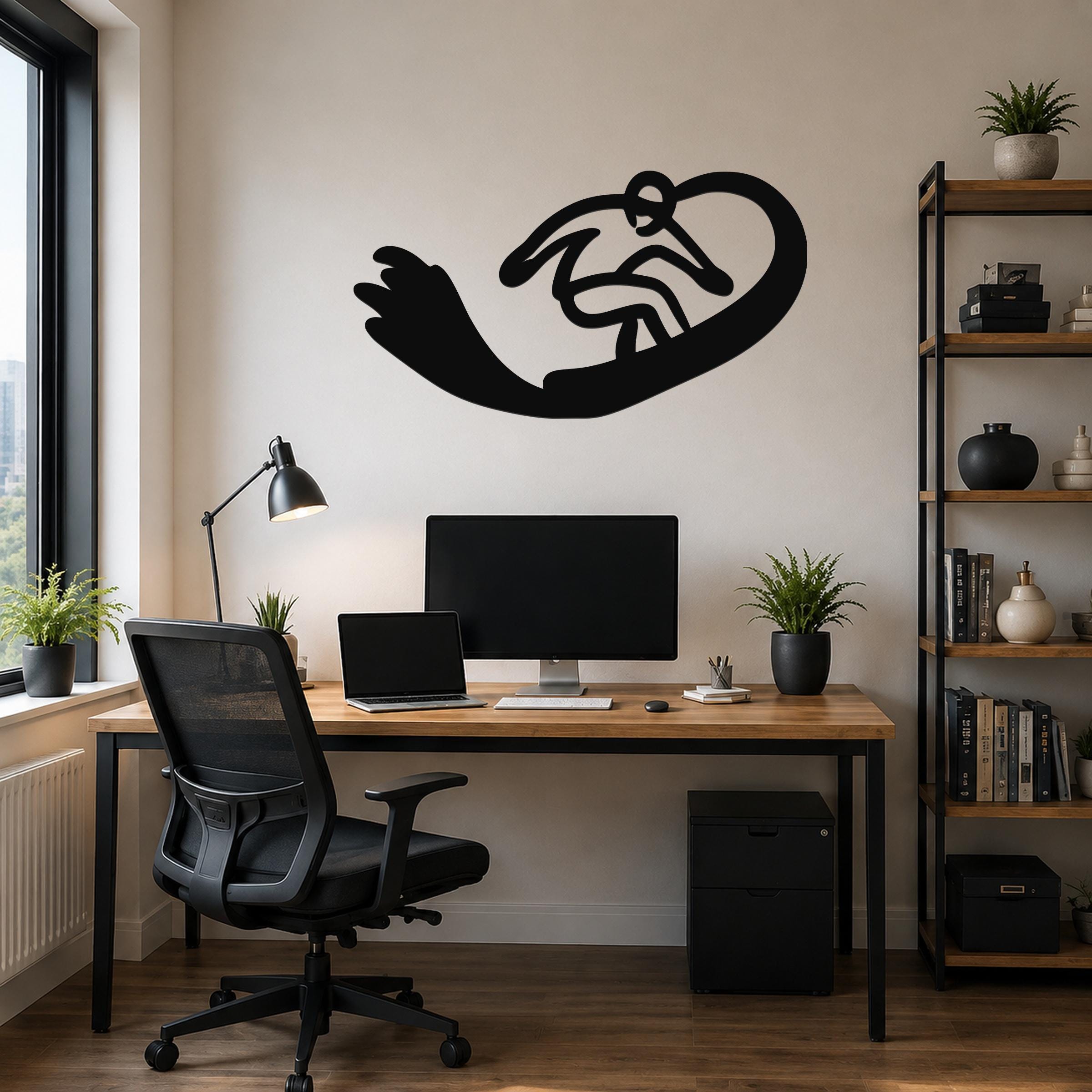 Black metal wall art silhouette of a snowboarder in motion, mounted above a wooden desk in a modern home office.