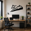 Black metal wall art silhouette of a snowboarder on a wave with mountains, mounted above a wooden desk in a home office.