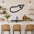 Black metal eggplant wall art silhouette mounted on a kitchen wall above a counter with wicker bar stools.