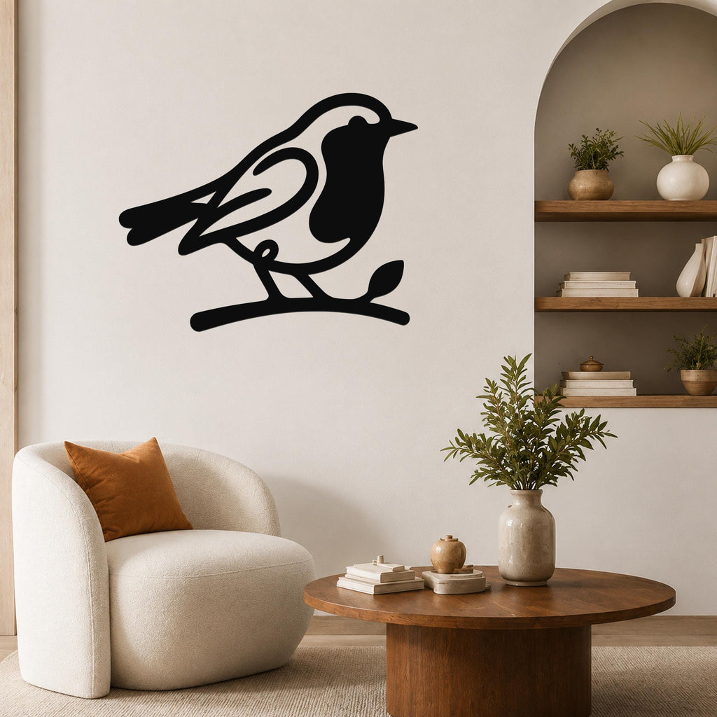 Black metal robin wall art silhouette perched on a branch, mounted on a living room wall above a white armchair.