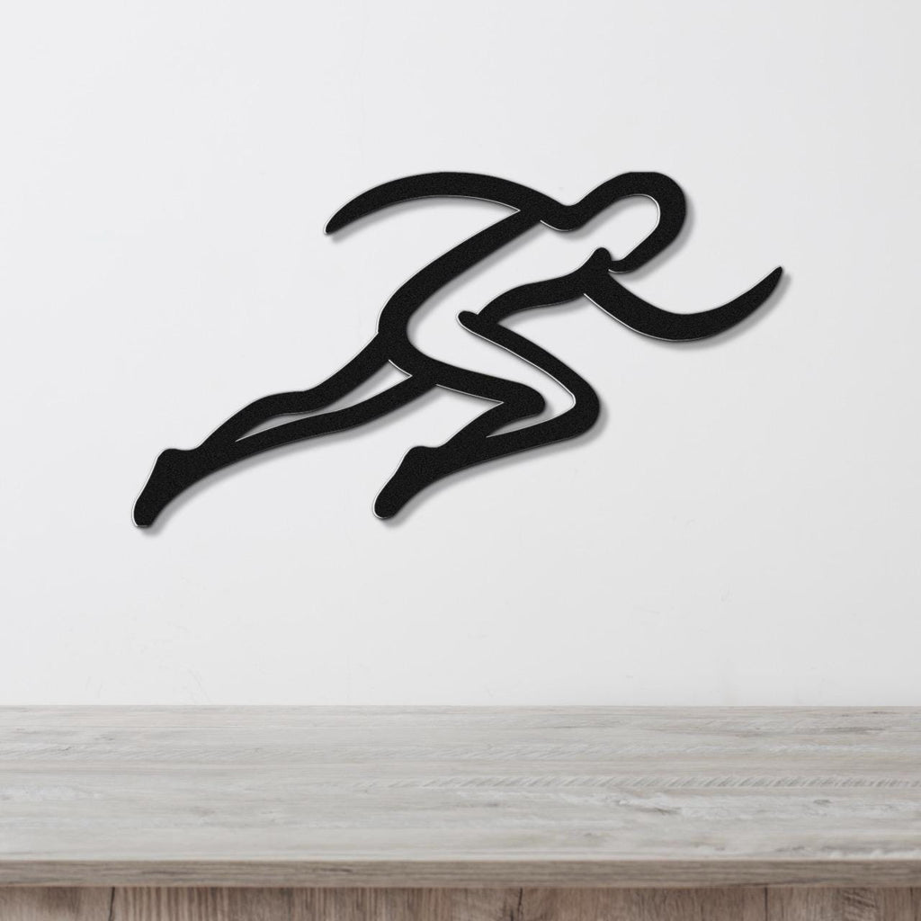 Black metal runner wall art with motion-line cutouts, mounted on a white wall above a light wood counter.