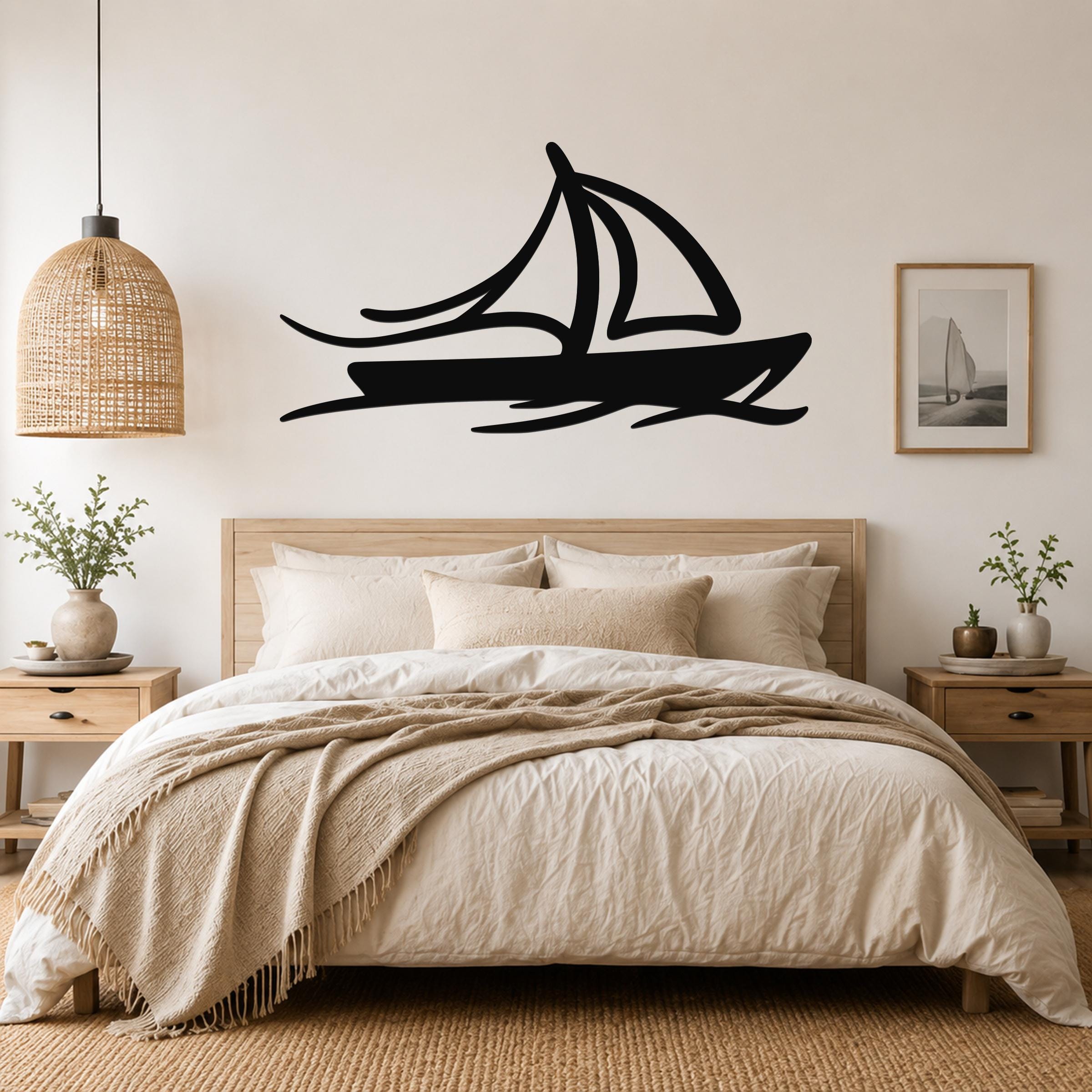 Black metal sailboat wall art with motion-line cutouts, mounted above a bed in a neutral bedroom.