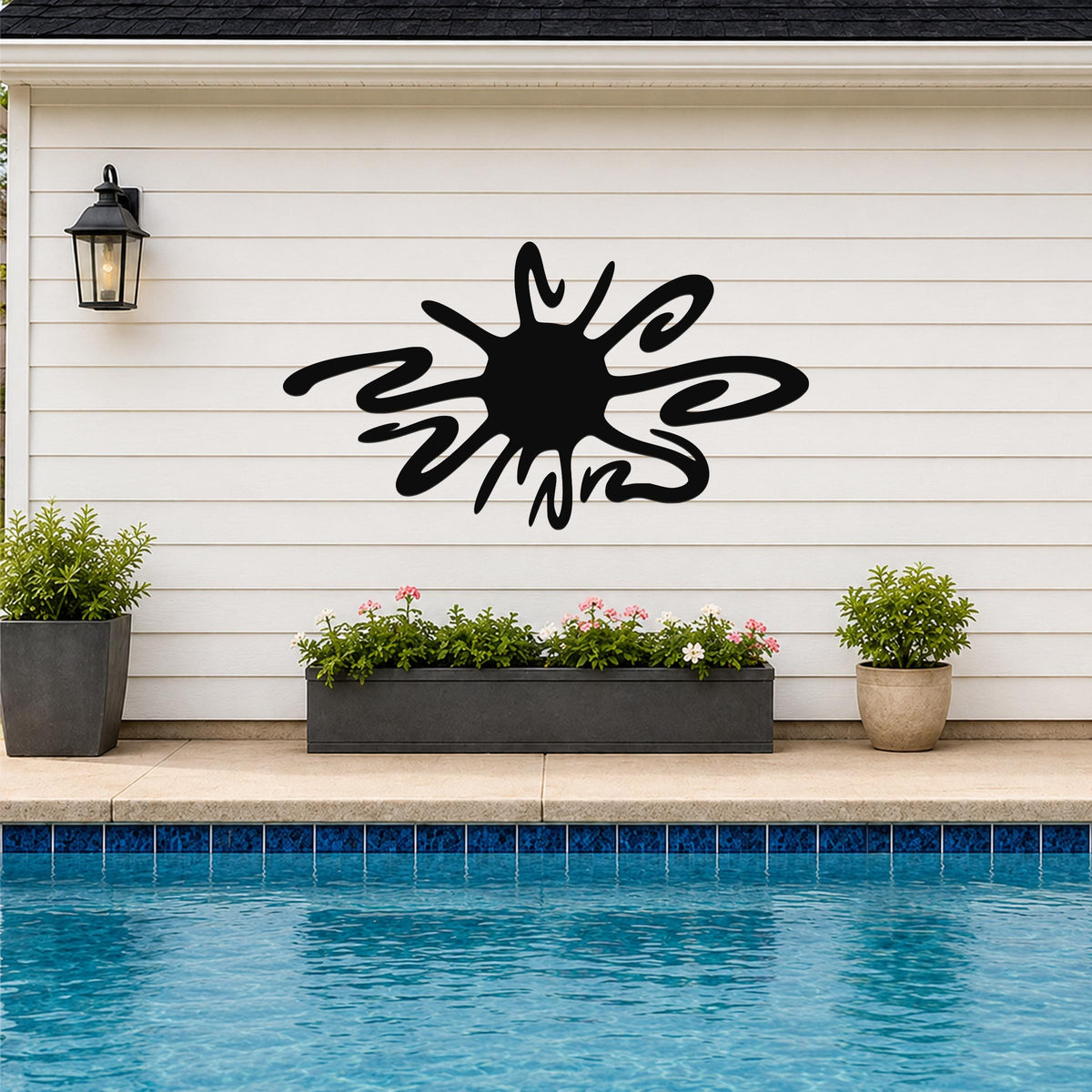 Black metal sea urchin wall art with spiky cutout design, mounted on a white horizontal siding wall above a poolside planter.