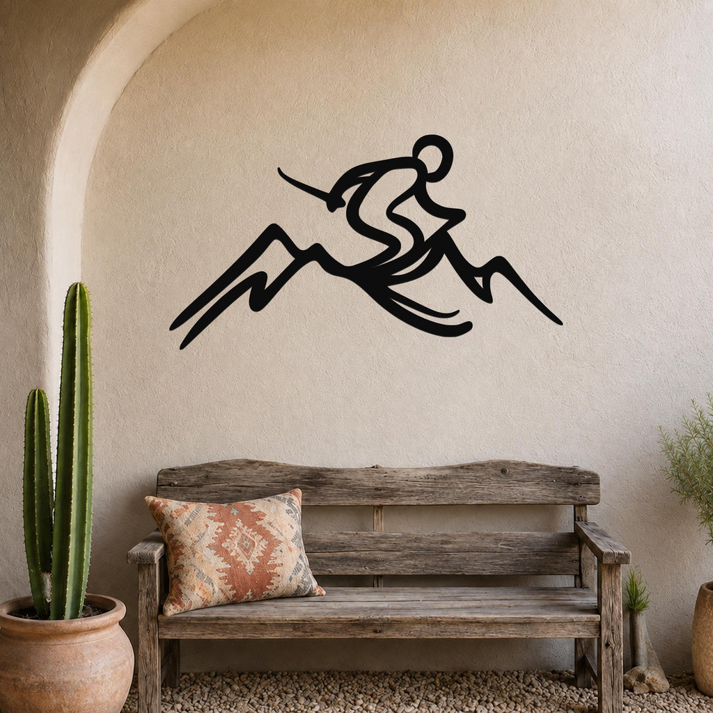 Black metal wall sculpture of a skier in motion above a mountain, mounted on a textured beige wall above a rustic wooden bench in a patio setting.