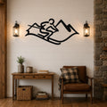 Black metal wall art featuring a skier silhouette and mountain peaks, mounted on a shiplap wall above a wooden console table in a rustic living room.