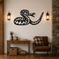 Black metal snake wall art with intricate internal cutouts, mounted on a shiplap wall above a wooden console table in a living room.