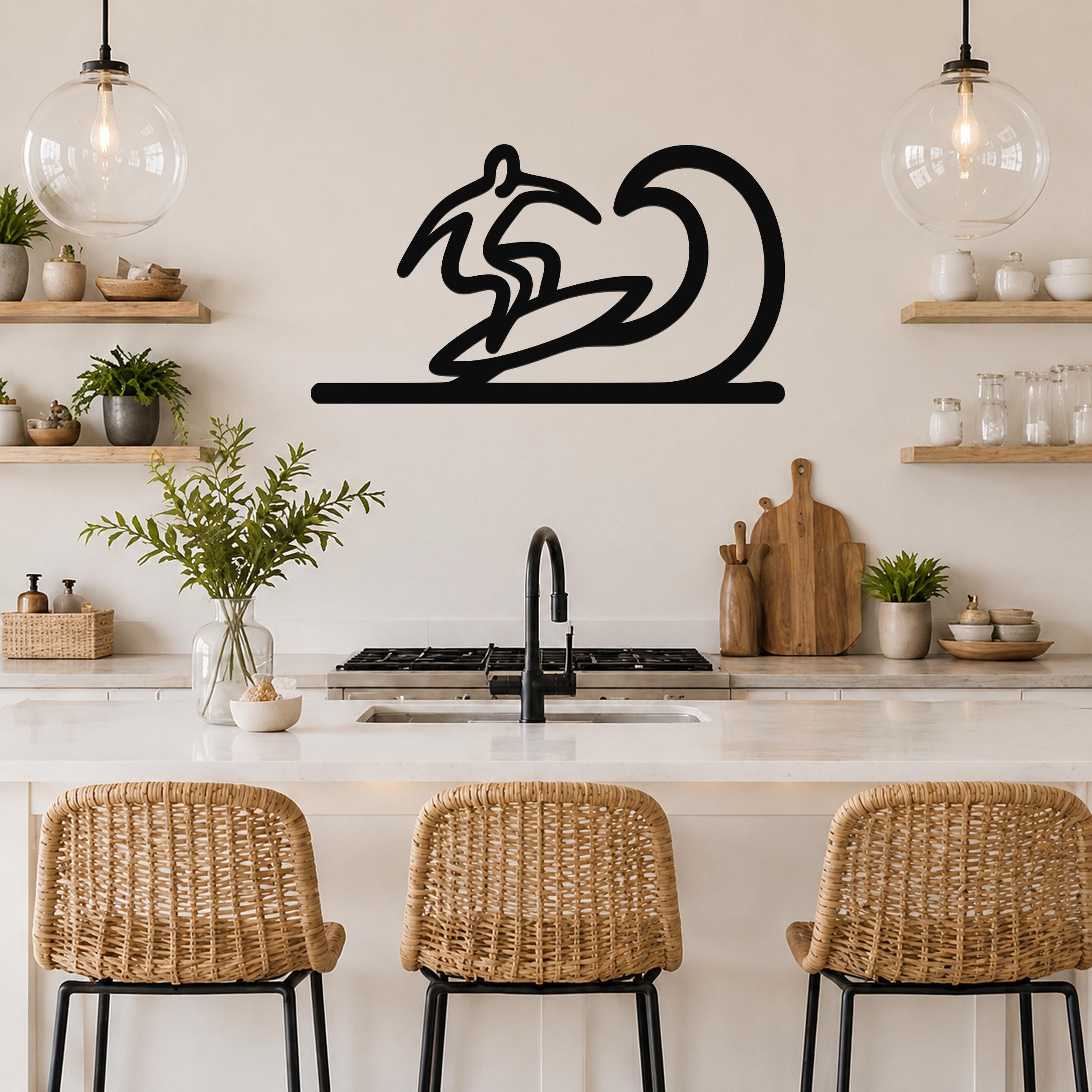 Black metal surfer wall art with a wave silhouette, mounted above a kitchen counter in a bright, modern kitchen.