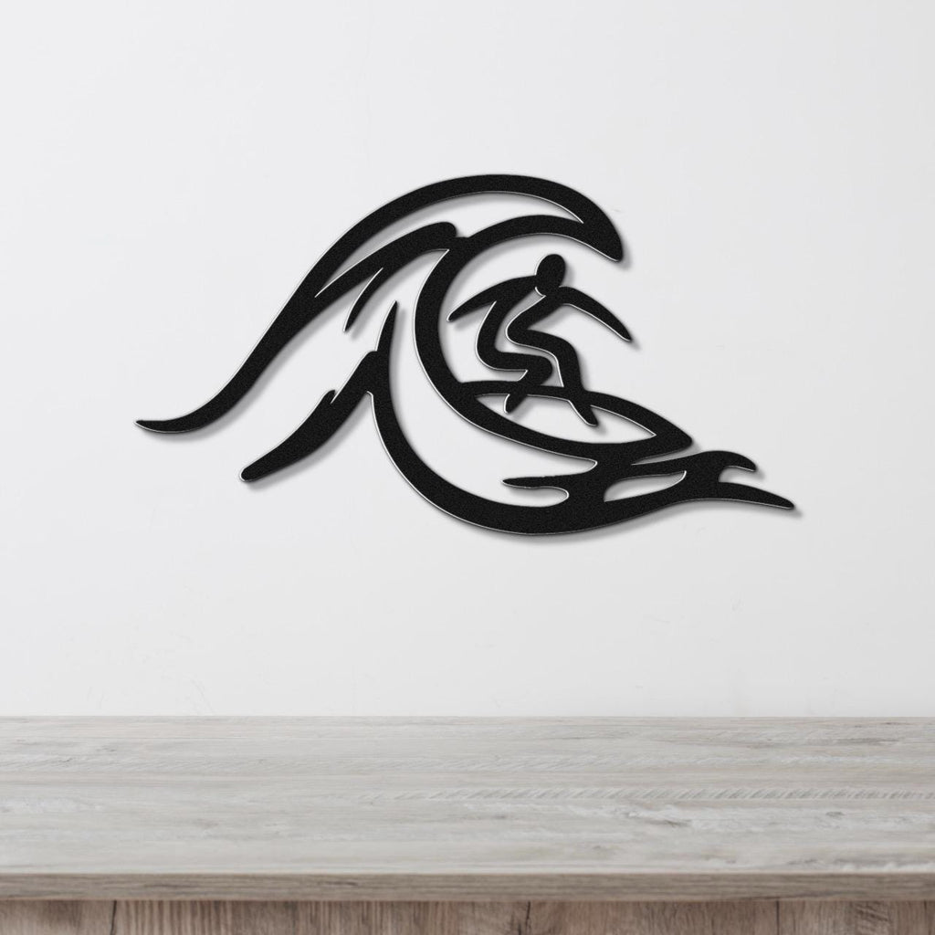 Black metal wall art featuring a surfer silhouette riding a wave, mounted on a white wall above a wooden surface.