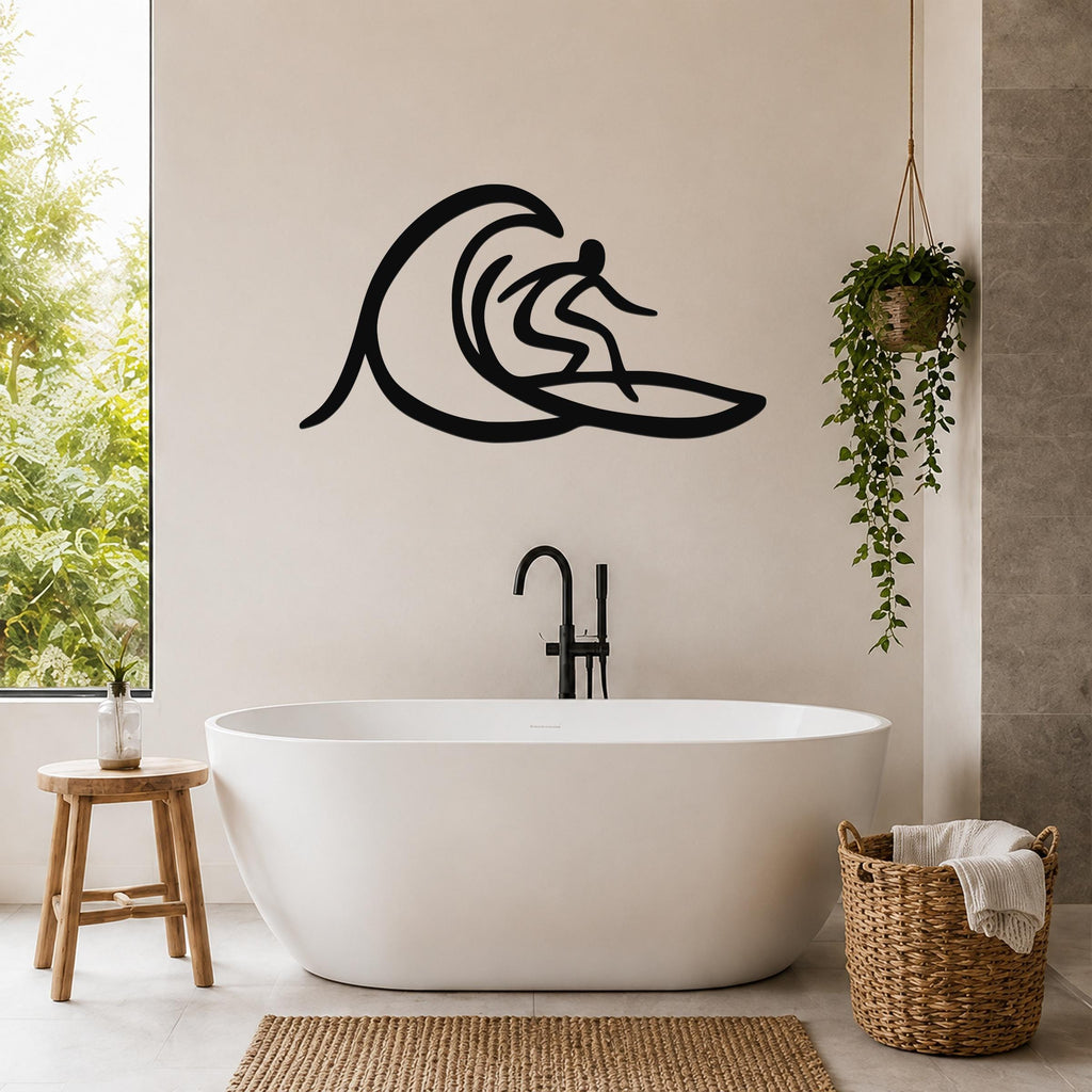 Black metal surfer wall art with wave silhouette, mounted on a bathroom wall above a freestanding tub.