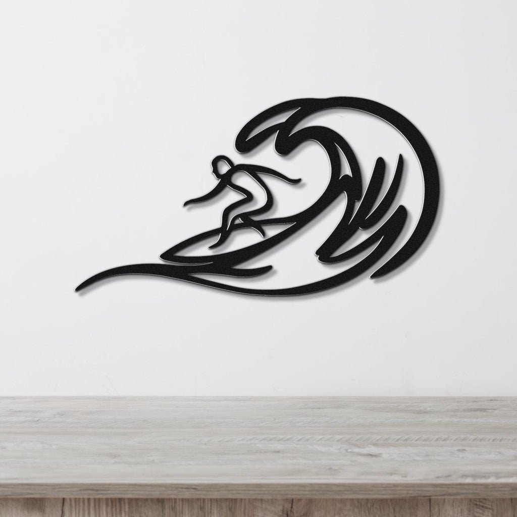Black metal surfer wall art with wave cutouts, mounted on a white wall above a wooden counter.