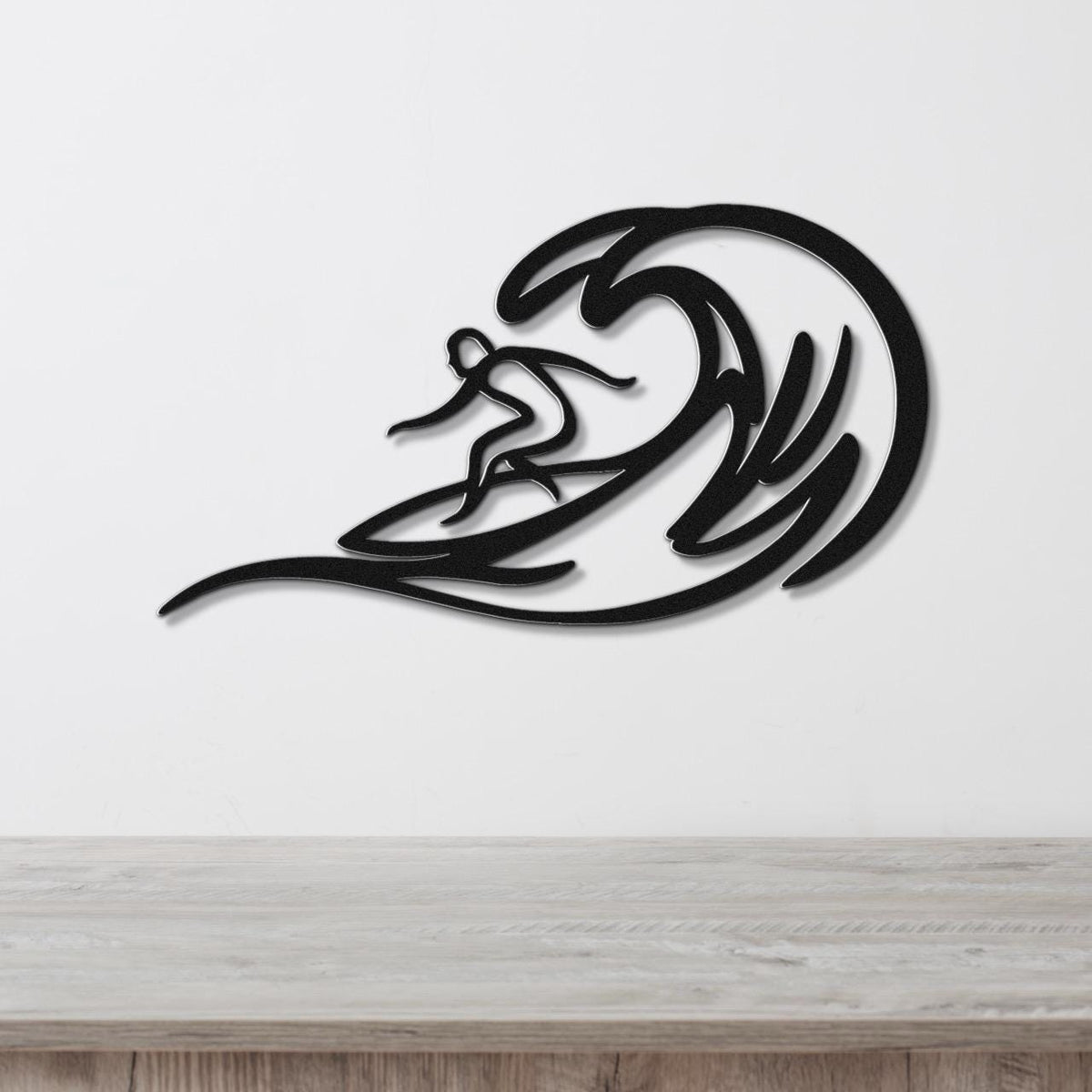 Black metal surfer wall art with wave cutouts, mounted on a white wall above a wooden counter.
