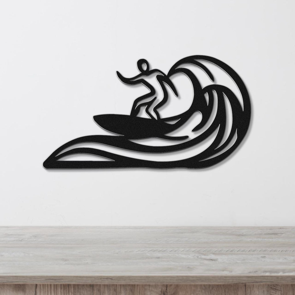 Black metal wall art featuring a surfer silhouette riding a wave, mounted on a white wall above a wooden surface.