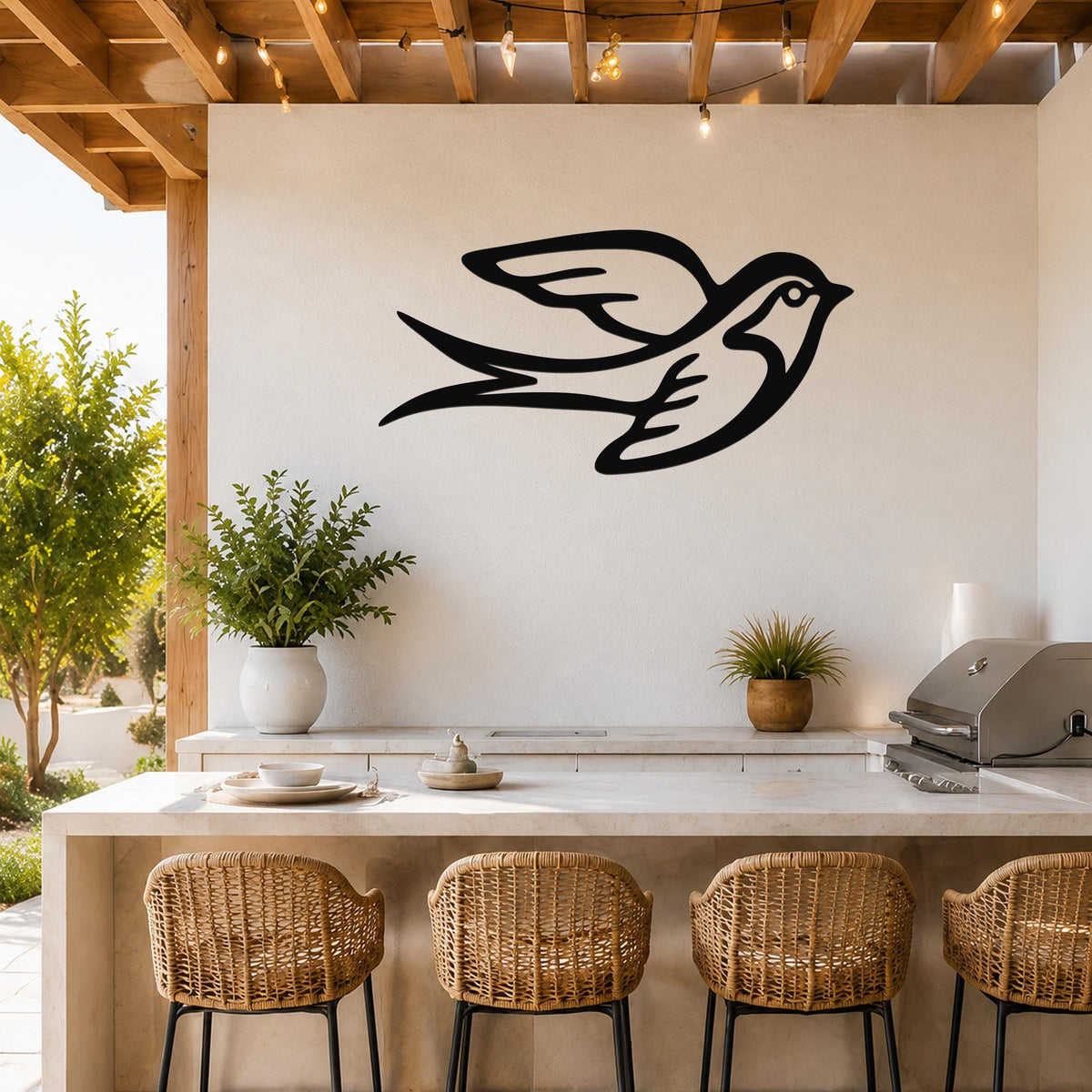Black metal swallow bird wall art with motion-line cutouts, mounted on a white outdoor wall above a kitchen counter.