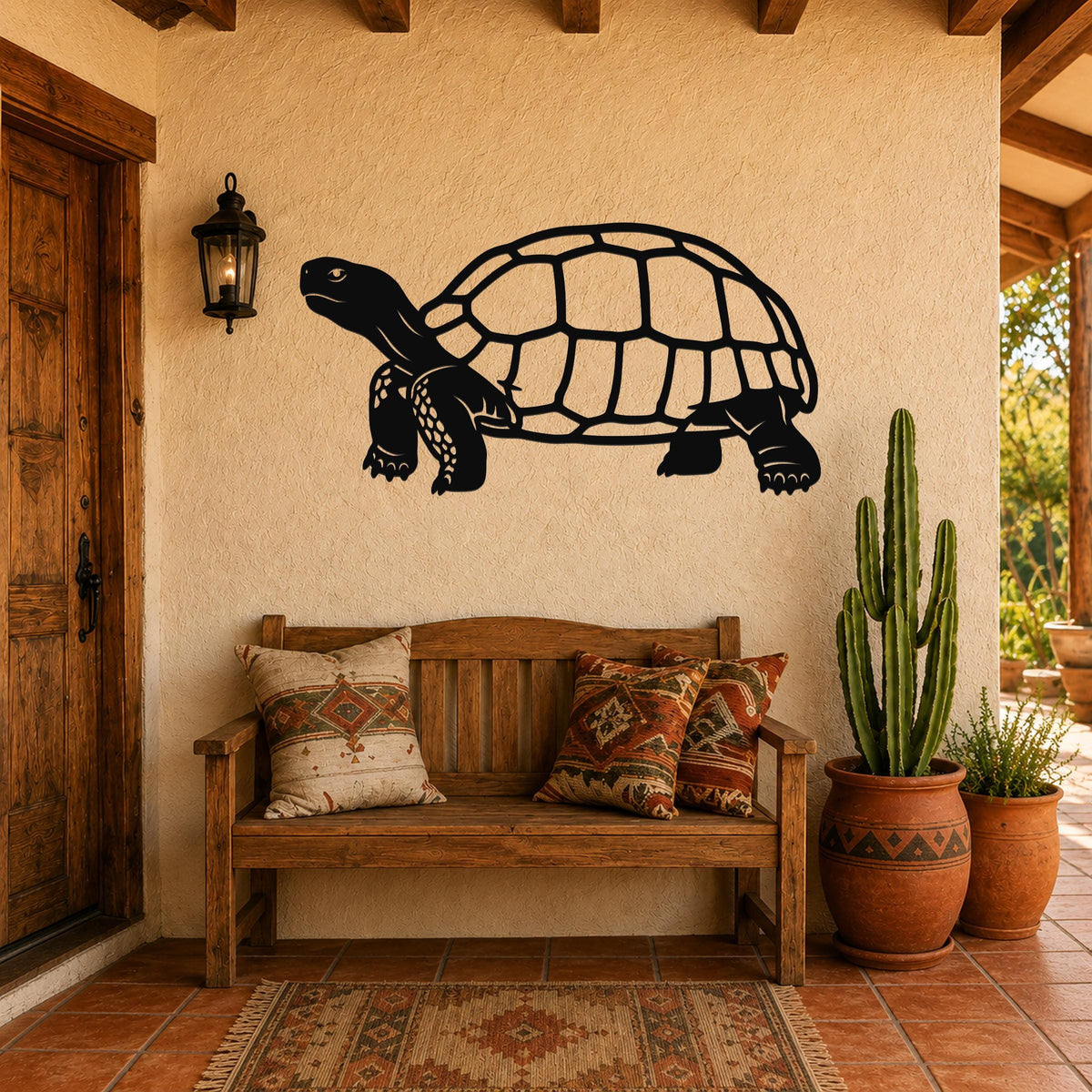 Black metal tortoise wall art with detailed shell and limb cutouts, mounted on a stucco wall above a wooden bench in a patio entryway.