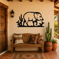 Black metal wall art silhouette of a javelina walking past cacti, mounted on a stucco wall above a wooden bench in a southwestern-style entryway.