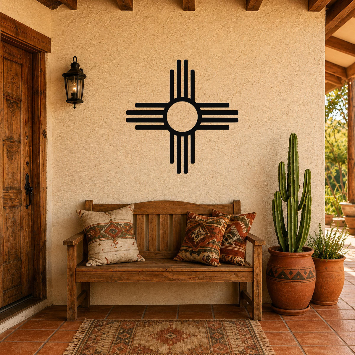 Black metal Zia Sun symbol wall art with bold circular design and radiating lines, mounted on a stucco wall above a wooden bench in a Southwestern-style patio.