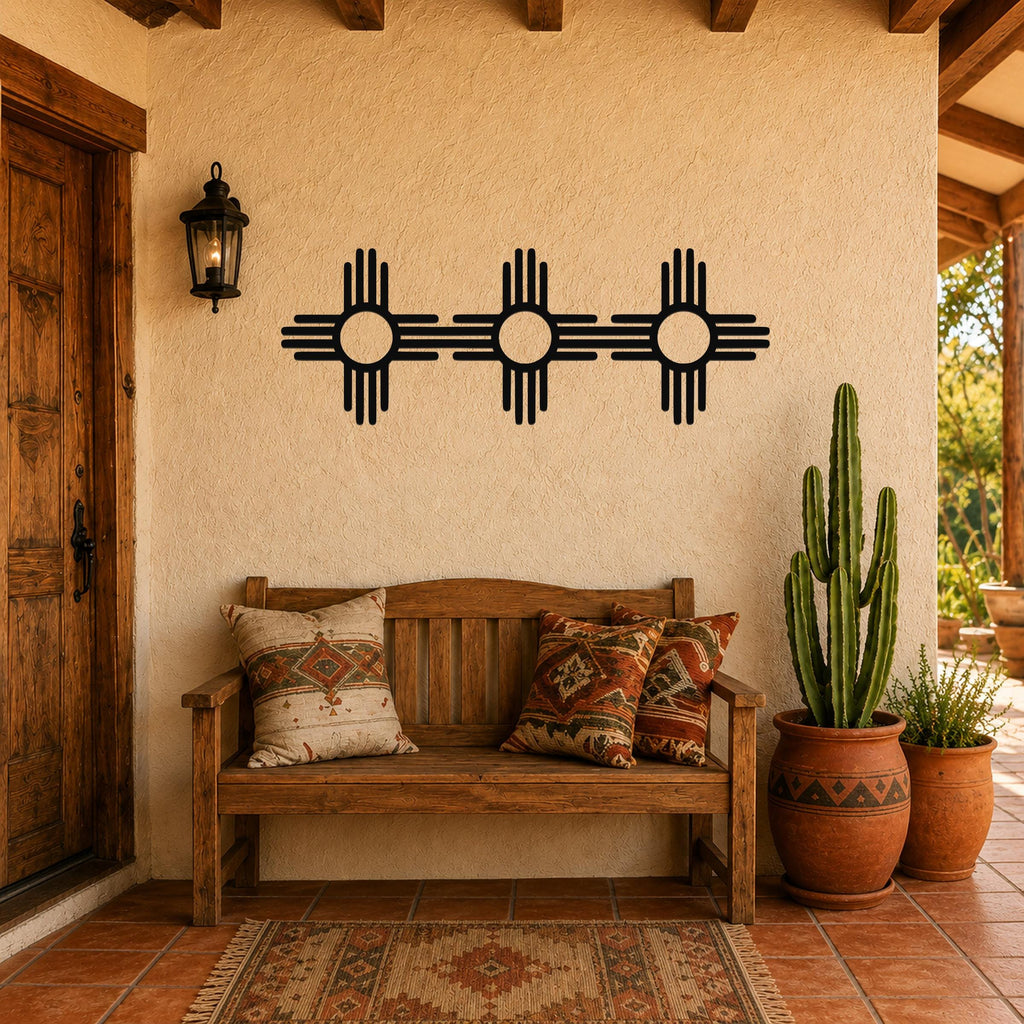 Black metal Zia Sun symbol trio wall art with four rays on each of three connected suns, mounted on a stucco wall above a wooden bench in a Southwestern-style entryway.