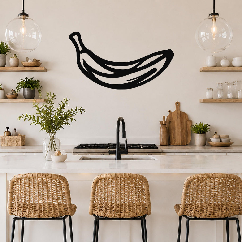 Black metal banana wall art with internal line cutouts, mounted on a kitchen wall above a counter.