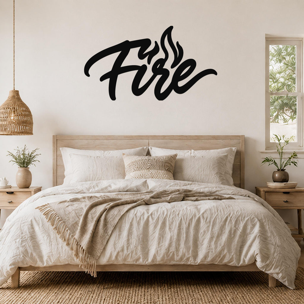 Black metal wall art with the word "Fire" in cursive script and flame cutouts, mounted above a wooden bed in a neutral bedroom.