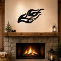 Black metal flame wall art with flowing silhouette cutouts, mounted above a stone fireplace in a rustic living room.