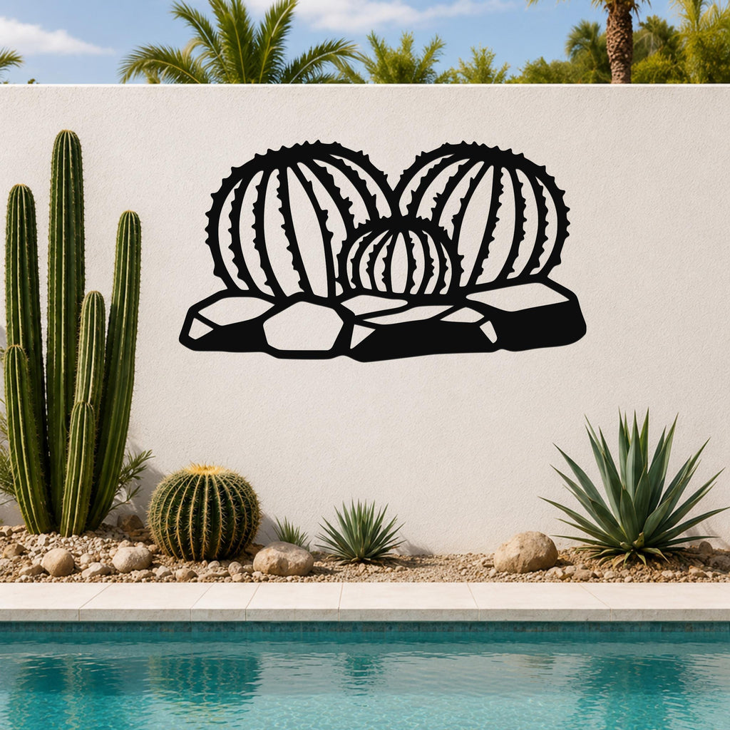 Black metal barrel cactus wall art with ribbed cutout design, mounted on a white outdoor wall above a poolside garden.