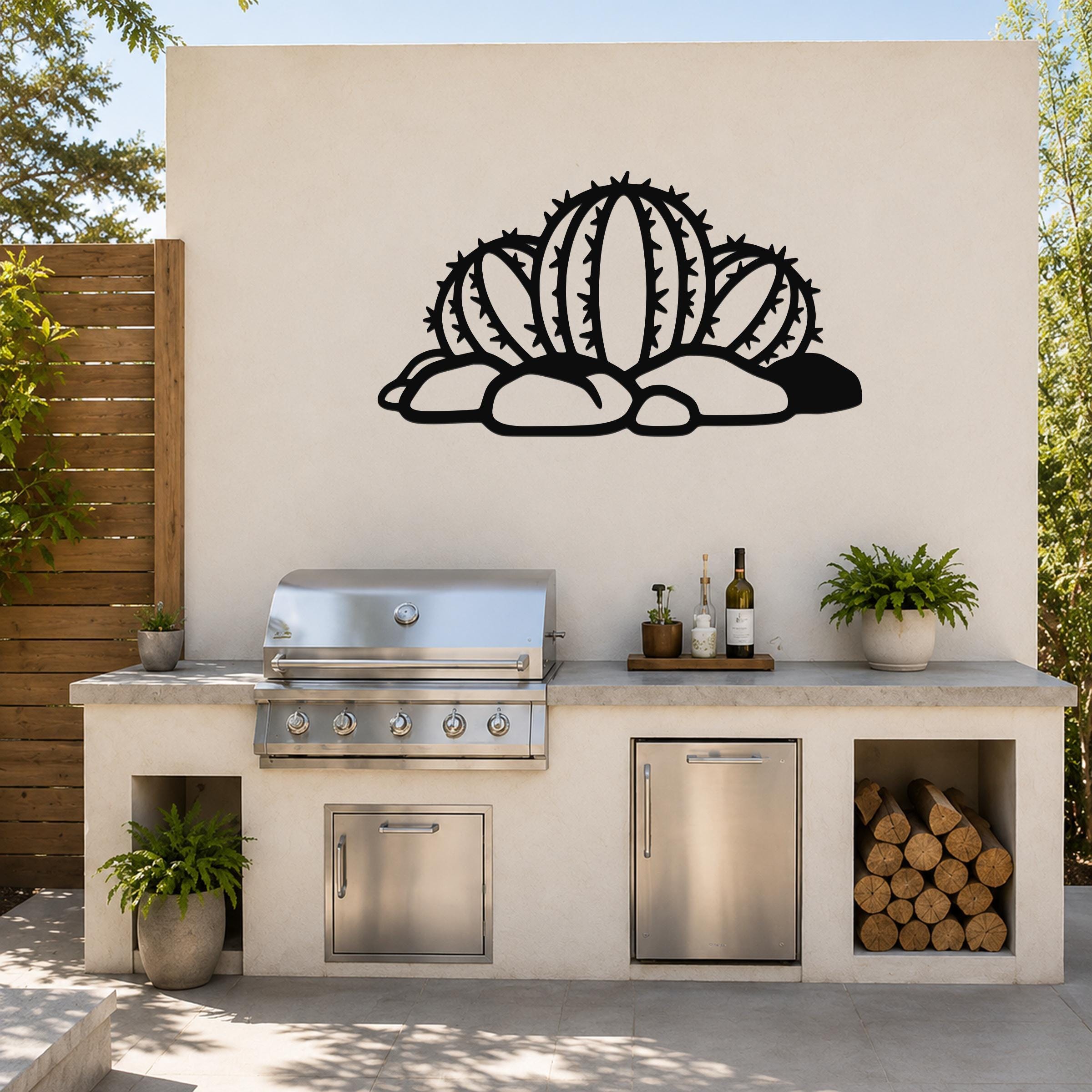 Black metal barrel cactus wall art with spines and cutout details, mounted on a white outdoor wall above a patio counter.