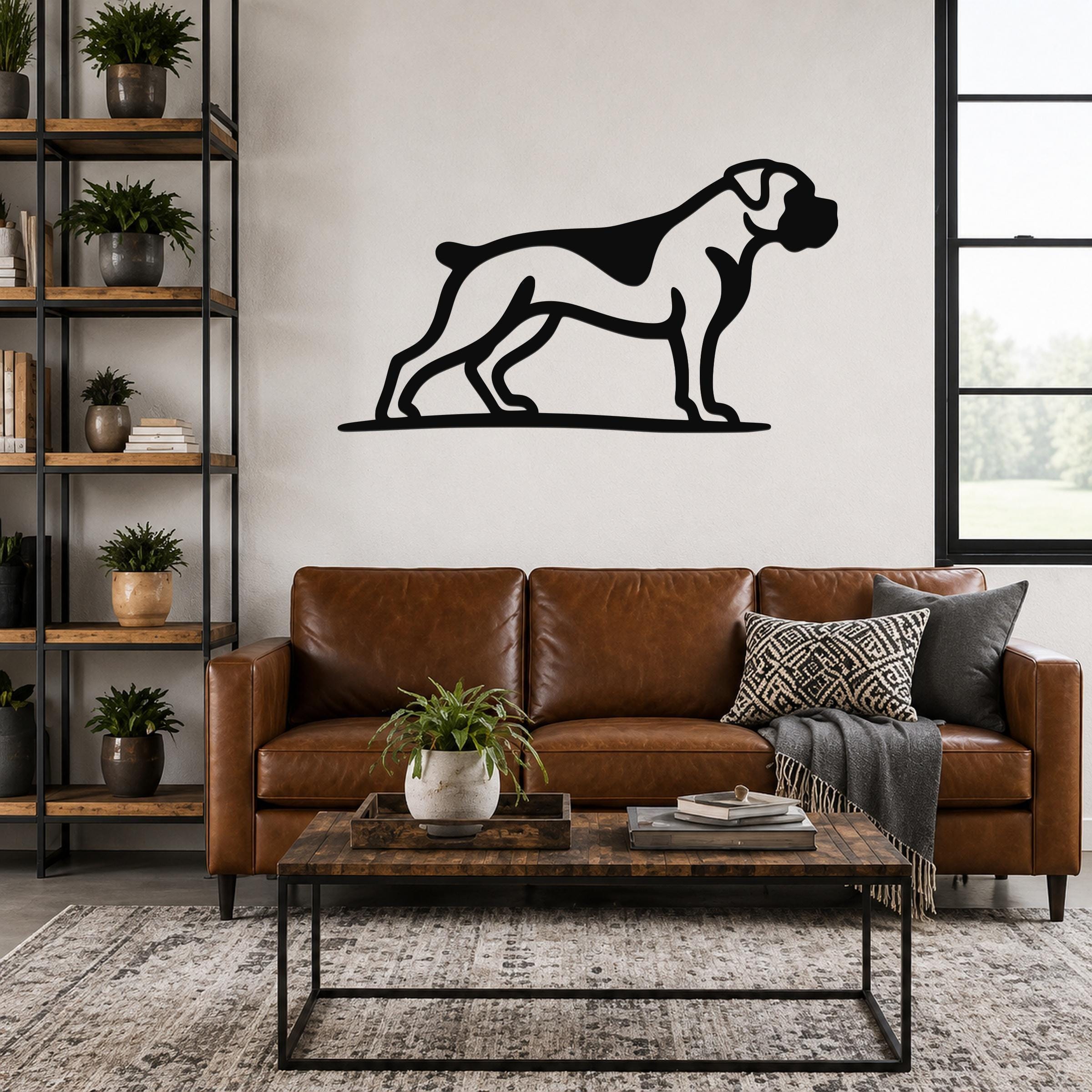Black metal Boxer dog wall art silhouette mounted above a brown leather sofa in a living room.