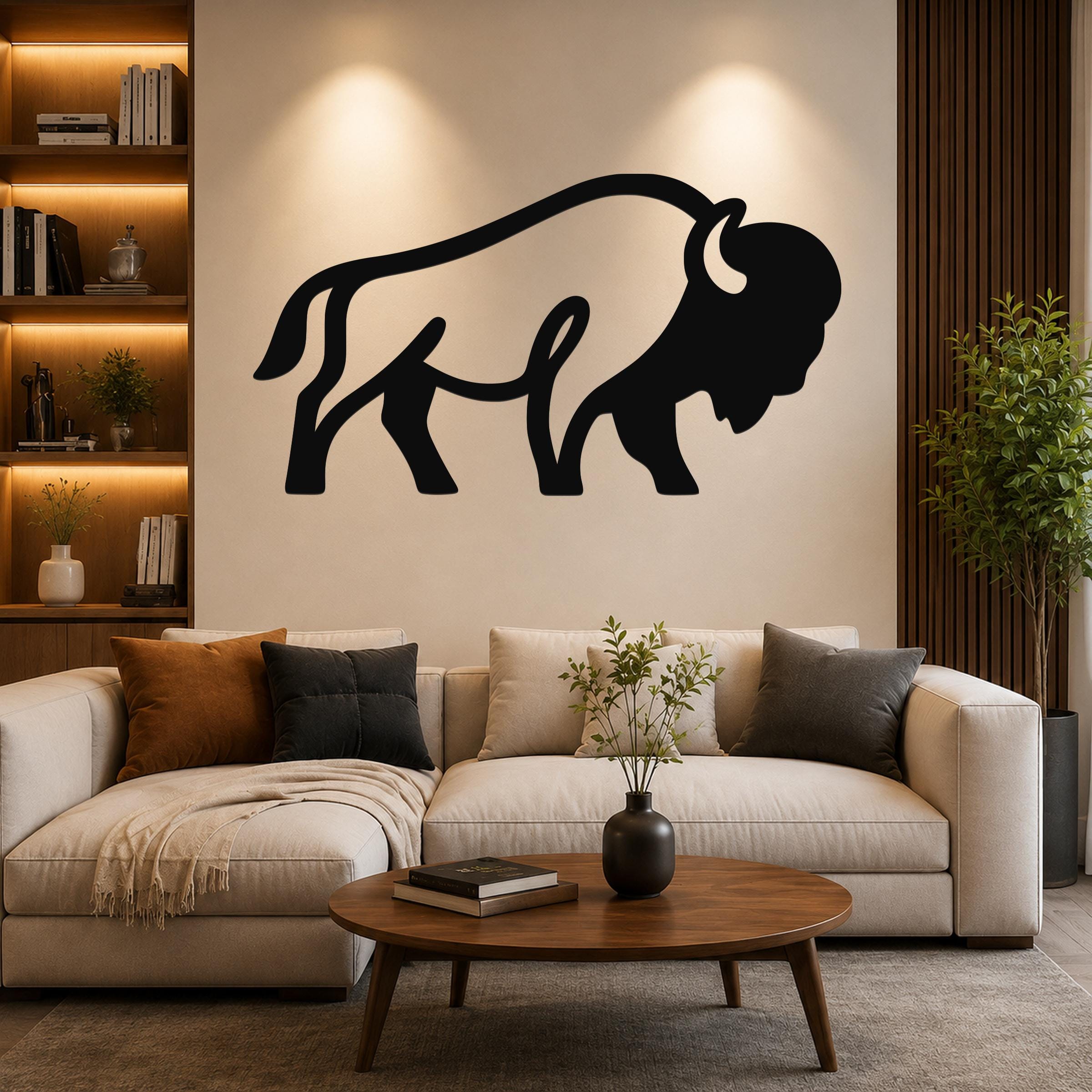 Black metal bison silhouette wall art mounted above a beige sofa in a living room with warm lighting and wooden accents.