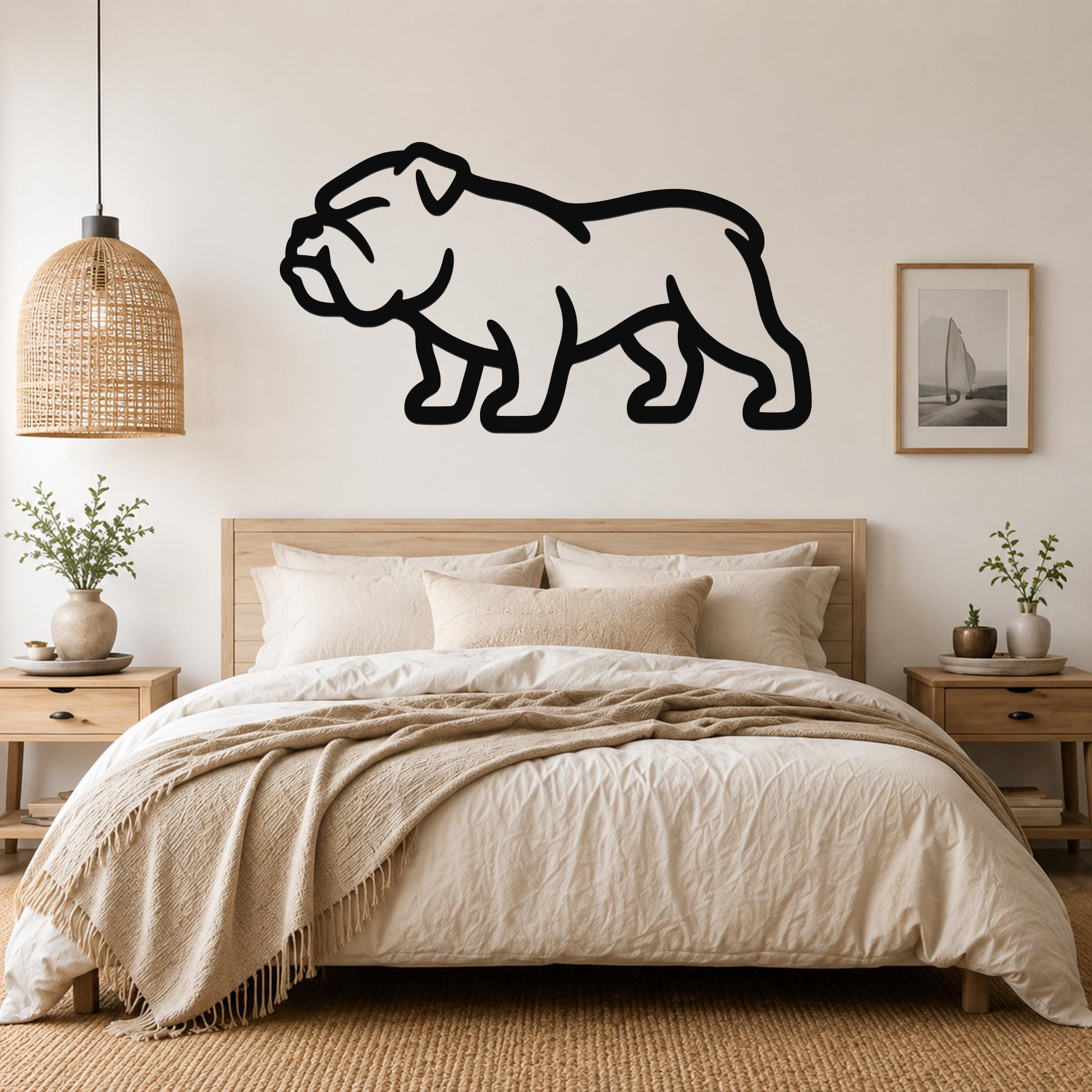 Black metal bulldog wall art silhouette mounted above a bed in a neutral bedroom.