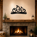 Black metal wall art with a flame and log silhouette, mounted above a stone fireplace in a rustic living room.