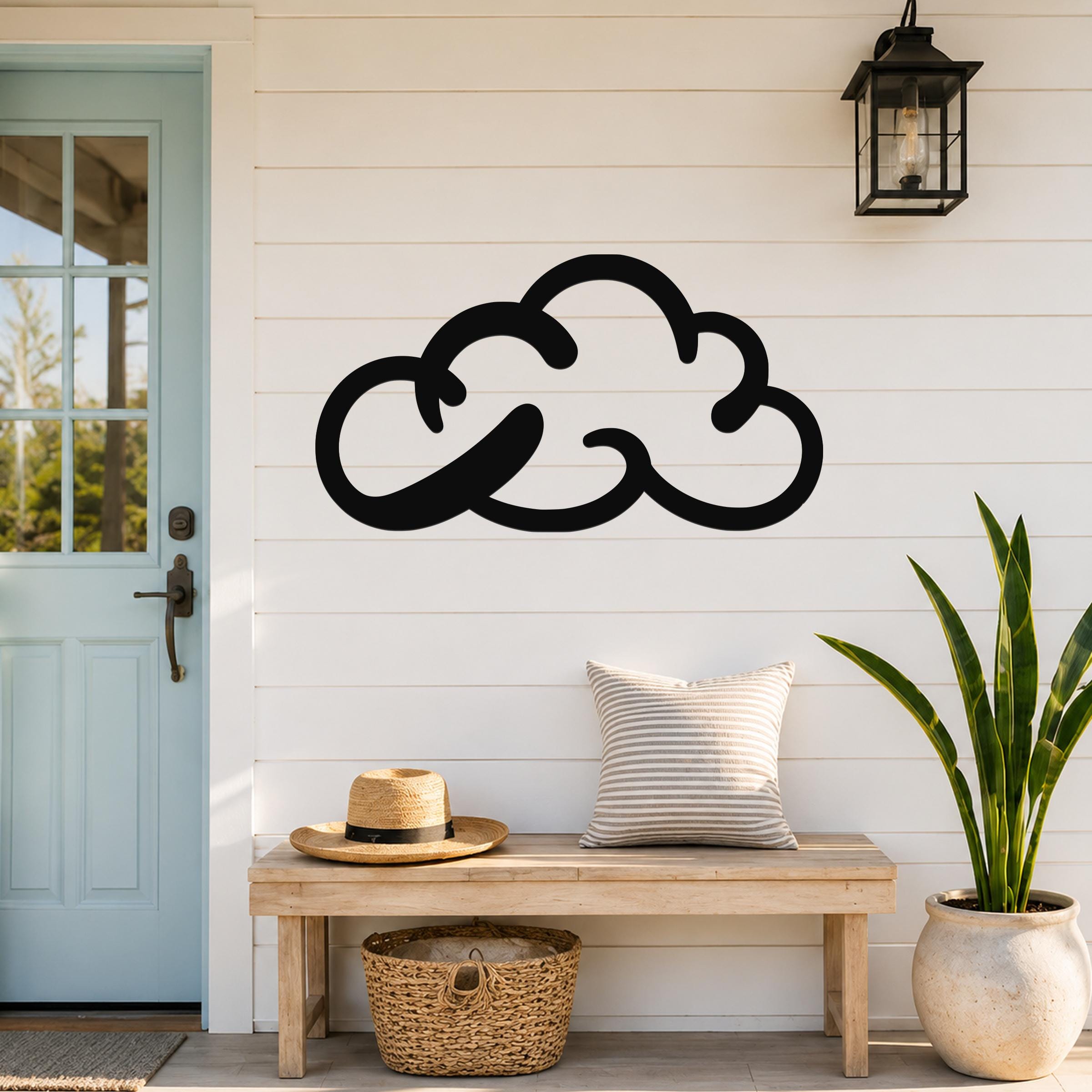 Black metal cloud wall art with a minimalist silhouette design, mounted on a white shiplap wall above a wooden bench in a front entryway.