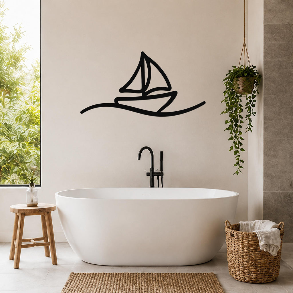 Black metal sailboat wall art with wave cutout, mounted on a bathroom wall above a freestanding tub.