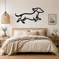 Black metal dachshund wall art in a running silhouette, mounted above a bed in a neutral bedroom.