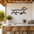 Black metal dachshund wall art with a running silhouette, mounted on a white outdoor wall above a kitchen counter.