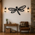 Black metal dragonfly wall art with cutout wings and body, mounted on a shiplap wall above a wooden console table in a living room.