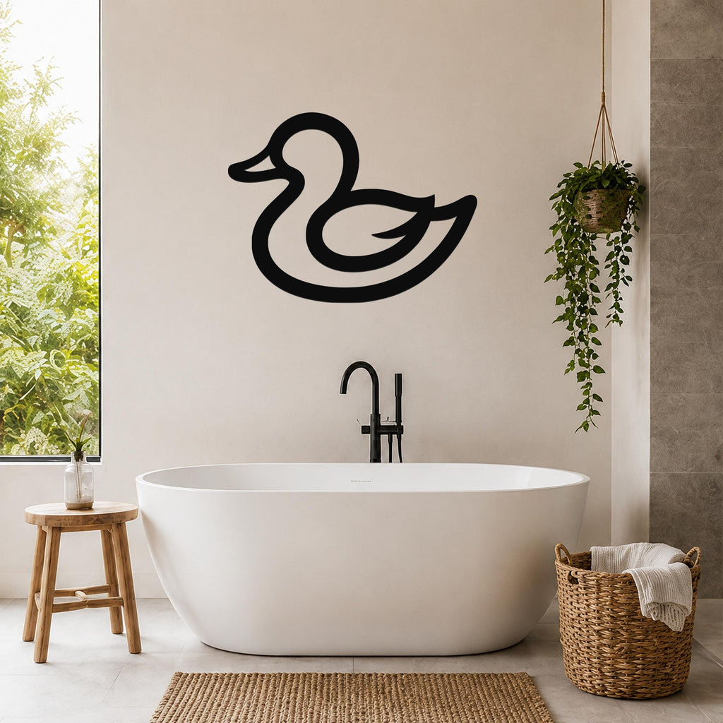 Black metal duck wall art silhouette mounted on a bathroom wall above a freestanding tub, with a hanging plant and woven basket nearby.