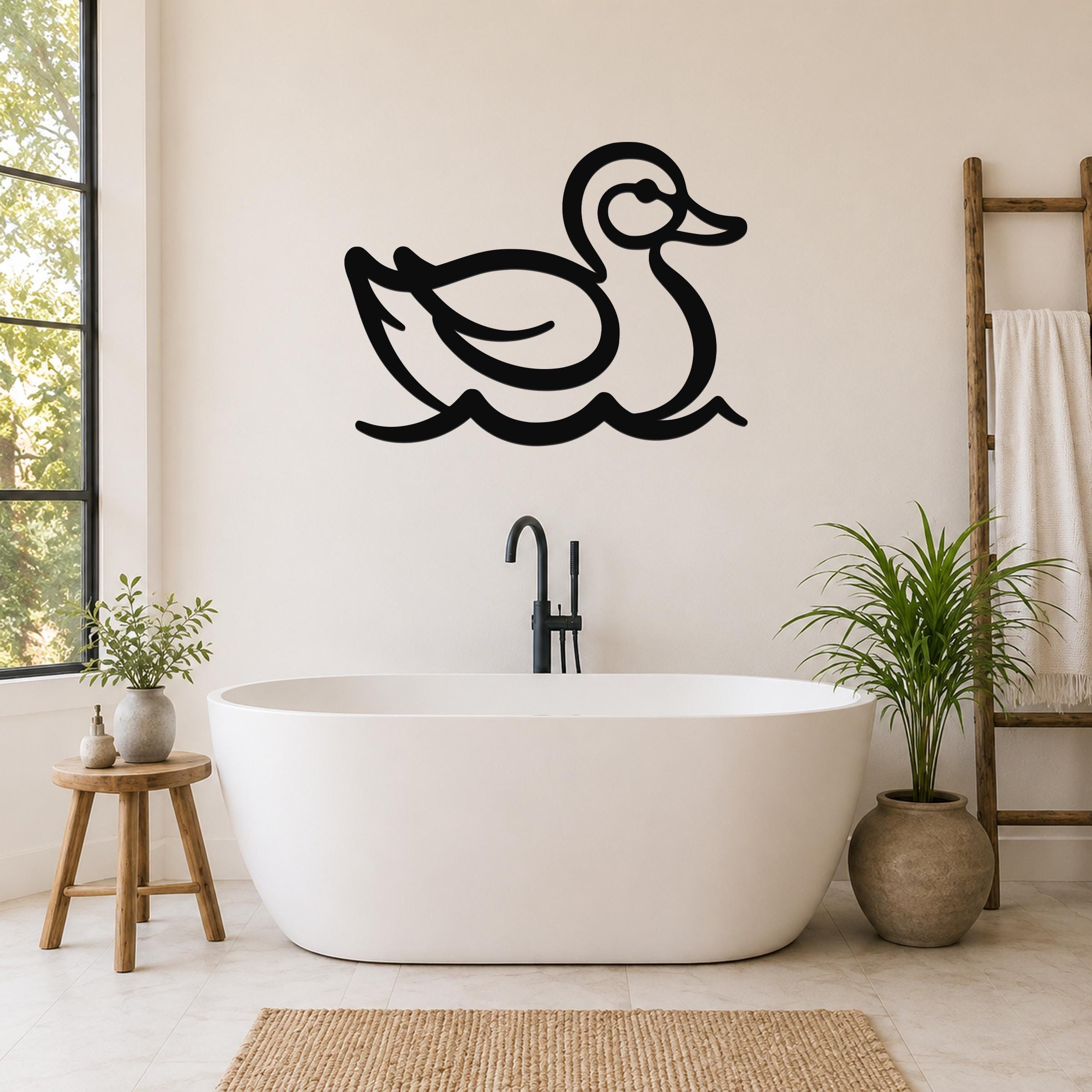 Black metal duck wall art silhouette with wavy water lines, mounted on a bathroom wall above a freestanding tub.