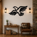 Black metal eagle wall art with a bold silhouette and extended wings, mounted on a shiplap wall above a wooden console table in a living room.