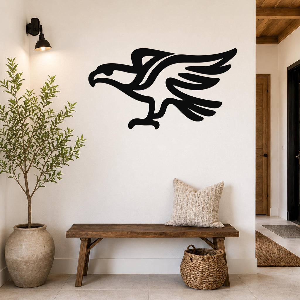 Black metal eagle wall art with a bold silhouette design, mounted on a white wall above a wooden bench in a modern entryway.