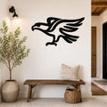 Black metal eagle wall art with a bold silhouette design, mounted on a white wall above a wooden bench in a modern entryway.