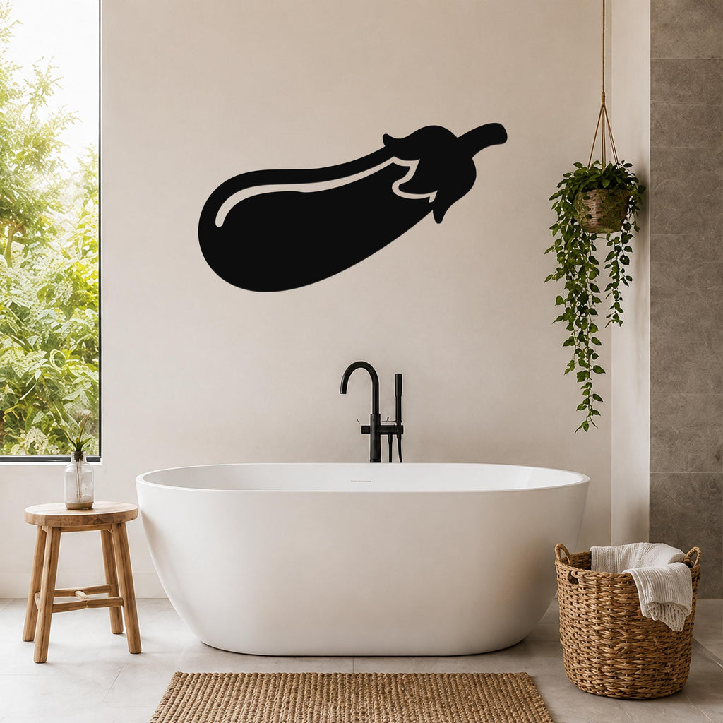 Black metal eggplant wall sculpture with a white outline, mounted on a beige bathroom wall above a freestanding tub.