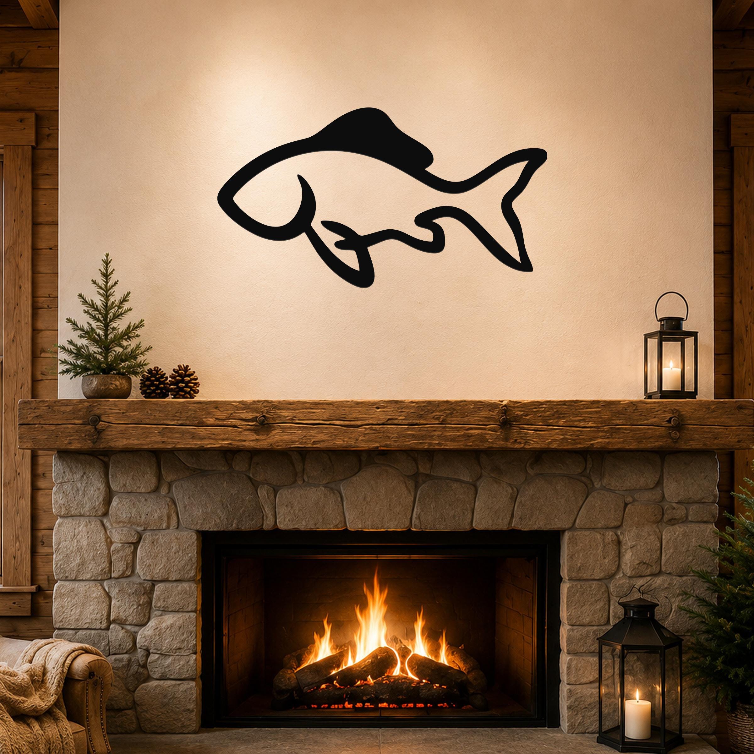 Black metal fish wall art with a graceful silhouette design, mounted above a stone fireplace in a rustic living room.