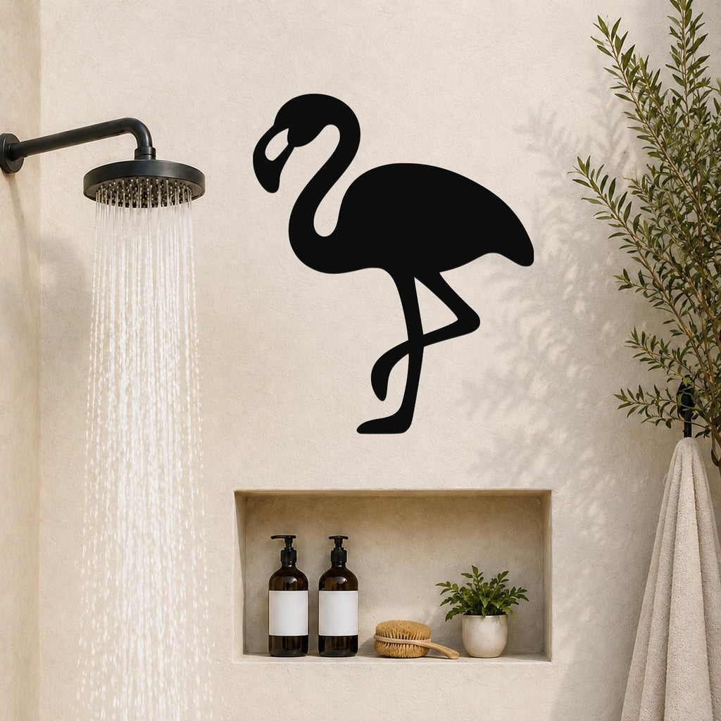 Black metal flamingo wall art silhouette mounted on a bathroom wall above a built-in shelf, near a running showerhead.