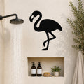 Black metal flamingo wall art silhouette mounted on a bathroom wall above a built-in shelf, near a running showerhead.