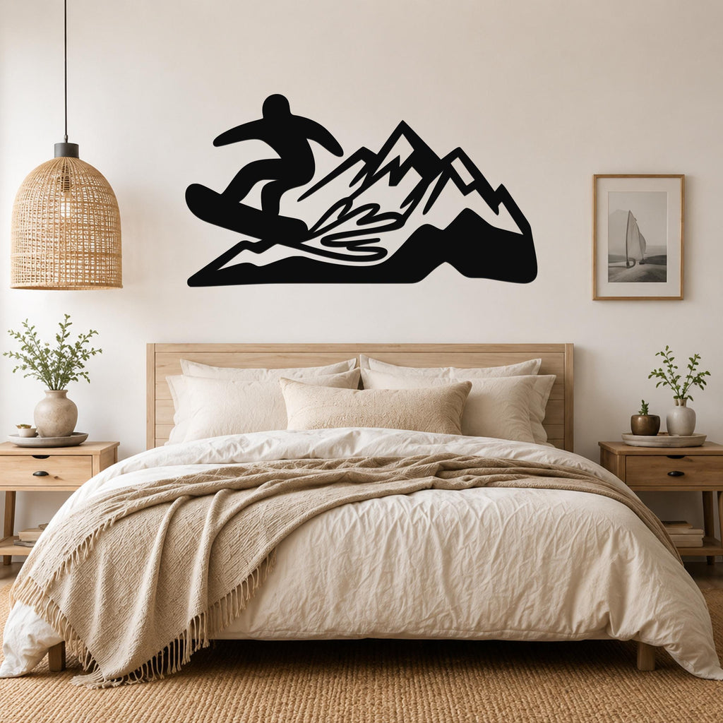 Black metal wall art featuring a snowboarder silhouette above a mountain range, mounted on a bedroom wall above a wooden bed.