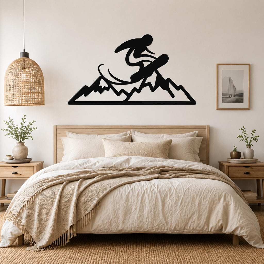 Black metal wall art featuring a snowboarder silhouette above a mountain range, mounted above a bed in a bedroom.