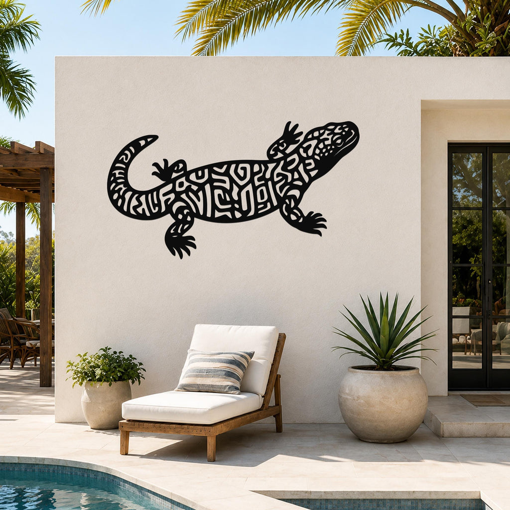 Black metal wall art of a Gila monster with intricate cutout patterns, mounted on an outdoor patio wall above a lounge chair near a pool.